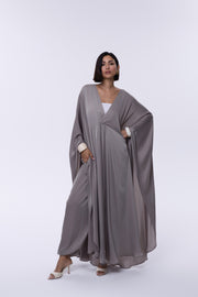 Woman wearing a gray abaya on a white background